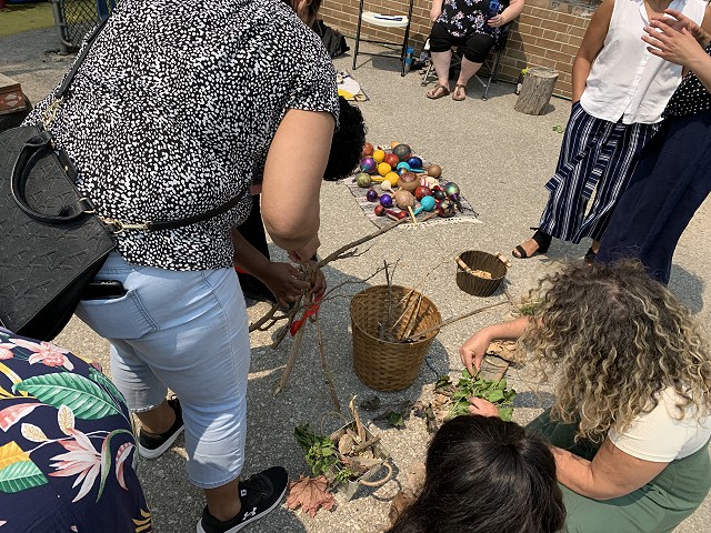 people collecting natural items in a basket, such as sticks
